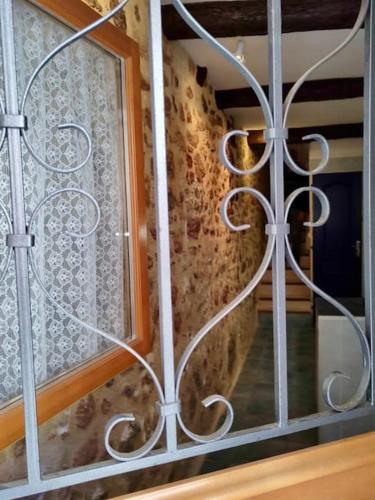 une porte en métal avec une fenêtre dans une pièce dans l'établissement Maison de charme - proche toutes commodités, à Marseillan