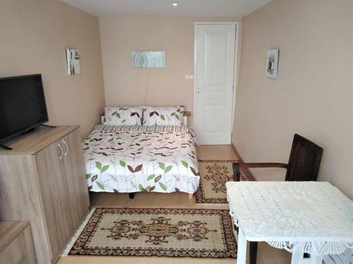 une chambre avec un lit, une table et une télévision dans l'établissement Maison de charme - proche toutes commodités, à Marseillan