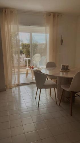 un salon avec une table et des chaises et une fenêtre dans l'établissement Sunrise, au Cap d'Agde