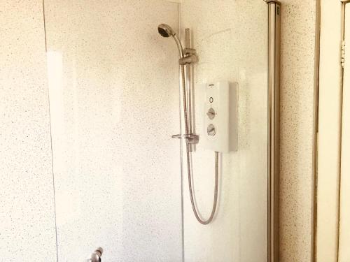 a shower with a shower head on a wall at Inverthorn House in Inverness