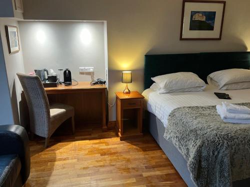 a hotel room with a bed and a desk with a telephone at Hedley House Hotel & Apartments in York
