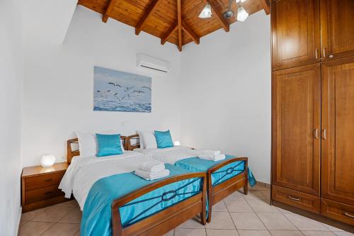 a bedroom with a bed with blue and white sheets at Sea view villa Stelios with Private pool Near the beach in Kalyves