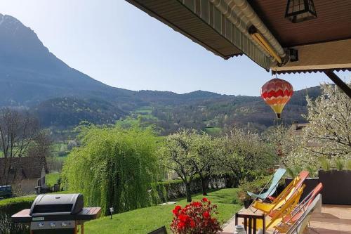 a hot air balloon flying over a yard with chairs at Maison de montagne in Saint Firmin