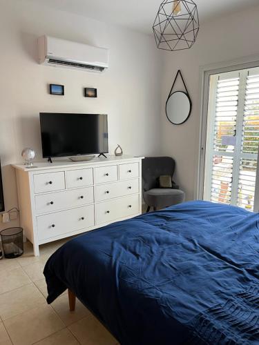 ein Schlafzimmer mit einem Bett und einer Kommode mit einem TV in der Unterkunft Mountain View Apartment - Polis in Polis Chrysochous