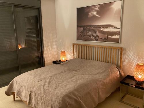 ein Schlafzimmer mit einem Bett mit zwei Lampen und einem Bild an der Wand in der Unterkunft Los Monteros Hill Club Marbella in Marbella