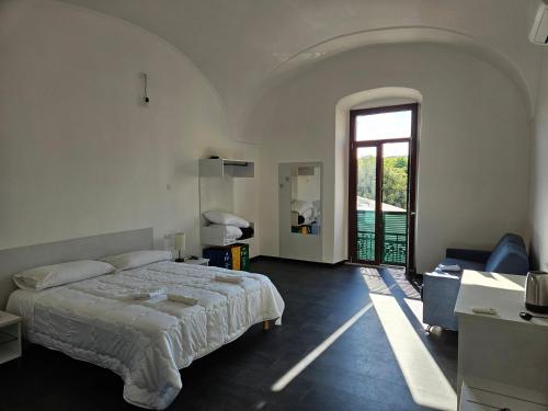 a bedroom with a bed and a large window at La Dama del Castello in Bosa