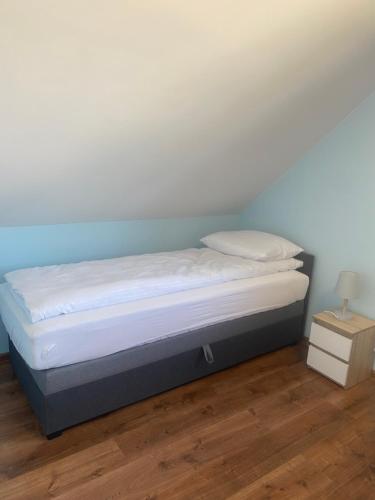 a bed in a room with a white wall at Biebrzańska Przystań 2 in Goniadz