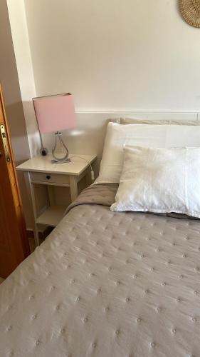 a bedroom with a bed with a lamp on a table at Casa con vista mare in Vlorë
