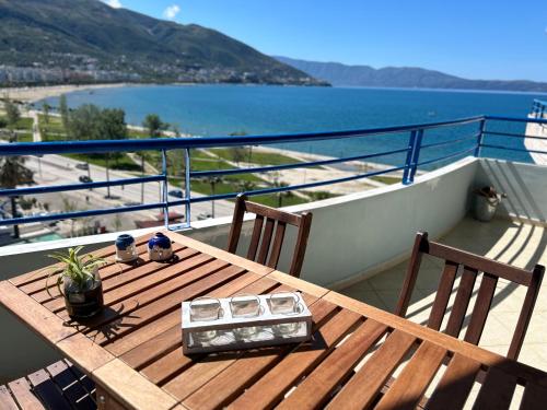 una mesa de madera en un balcón con vistas al océano en Casa con vista mare en Vlorë