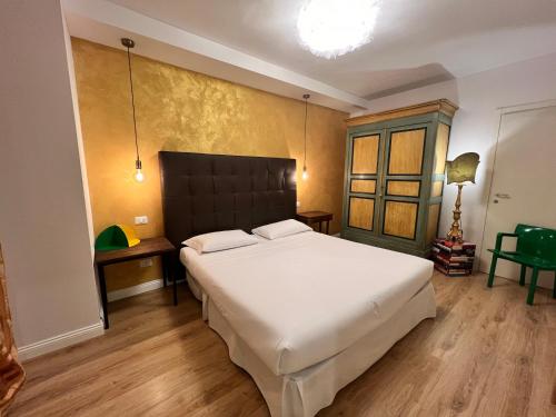 um quarto com uma grande cama branca e pisos em madeira em CorteViva Boutique Cottage em SantʼEgidio