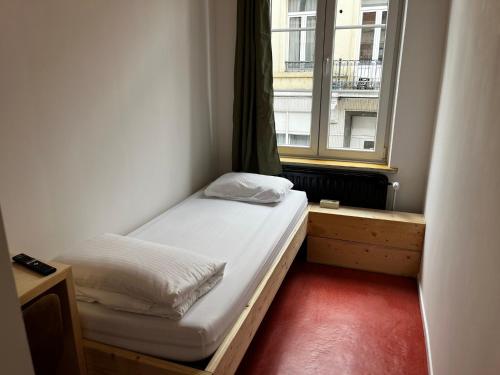 - une petite chambre avec un lit et une fenêtre dans l'établissement BED Pepin, à Namur