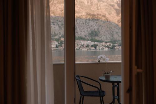 a table and a chair in front of a window at Apartments Biskupović in Muo