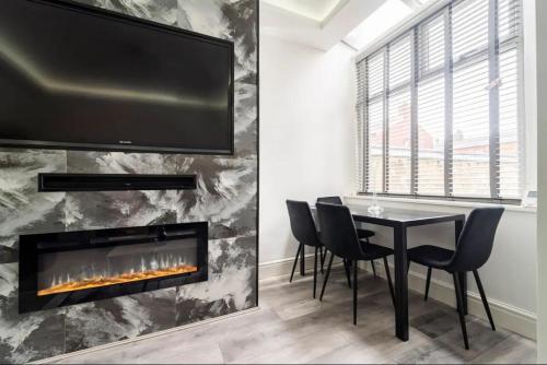 a dining room with a table and a fireplace at 3 bedroom house with modern interior, close to the Etihad stadium in Manchester