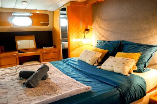 a bedroom with a large bed with a blue comforter at Yacht Aquamarina vieux port La Rochelle in La Rochelle