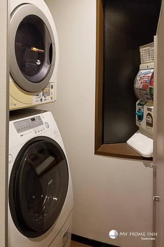 a washing machine and a microwave in a room at My Home Inn Izumisano in Izumi-Sano