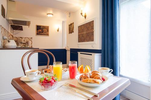 a table with a breakfast of croissants and orange juice at The Great Wave, appartement calme avec terrasse et parking gratuit in Ban-Saint-Martin