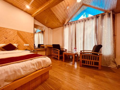 a bedroom with a bed and a desk and a window at Manali Castle - Wonder Hill in Manāli