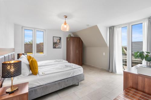 a bedroom with a large bed and windows at Amelie chez Inez in Radolfzell am Bodensee