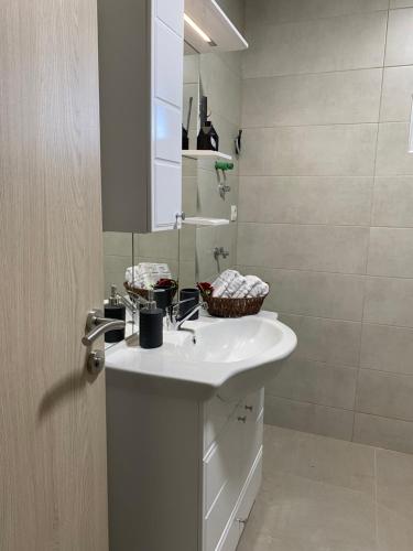 a bathroom with a white sink and a mirror at Apartmani Pranić in Mostar