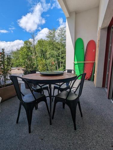 une table et deux chaises avec une table et des planches de surf dans l'établissement Mulintegiko Bidea, à Biriatou