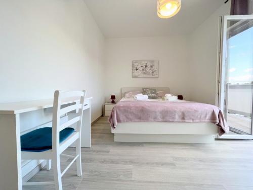 a bedroom with a bed and a desk and a window at Evergreen & Pinky Apartments close to the Beach in Rab