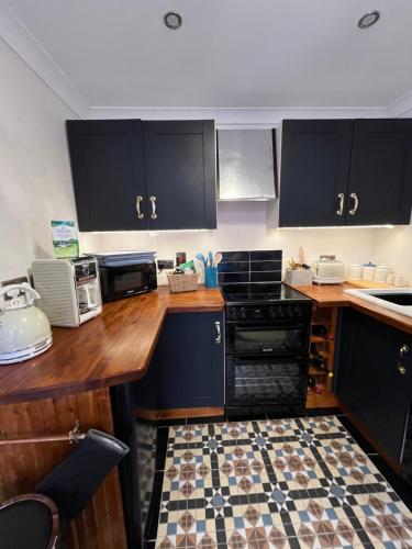cocina con armarios negros y encimera en Captain's Nook, Luxurious Victorian Apartment with Four Poster Bed and Private Parking only 8 minutes walk to the Historic Harbour en Brixham