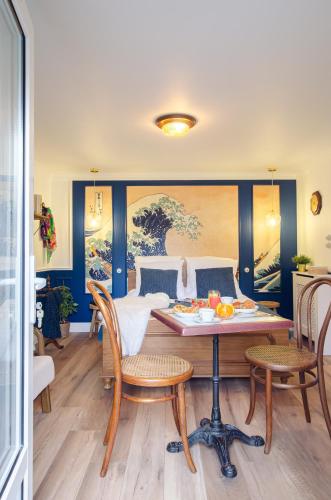 a dining room with a table and chairs at The Great Wave, appartement calme avec terrasse et parking gratuit in Ban-Saint-Martin