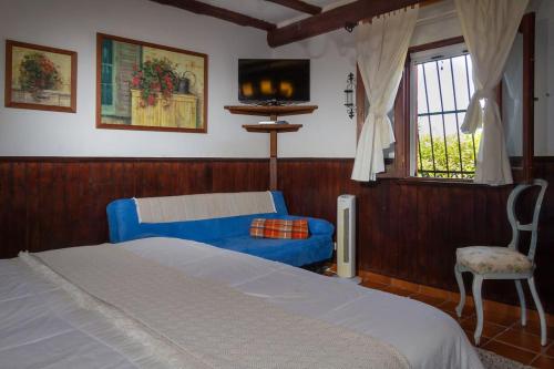 CASA RÚSTICA CON JACUZZI في لاس بالماس دي غران كاناريا: غرفة نوم بسرير ازرق ونافذة