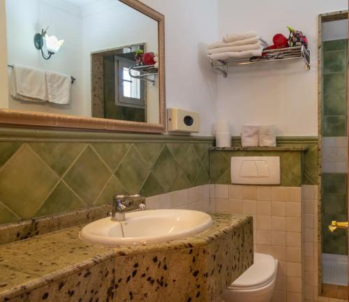 CASA RÚSTICA CON JACUZZI في لاس بالماس دي غران كاناريا: حمام مع حوض ومرحاض ومرآة