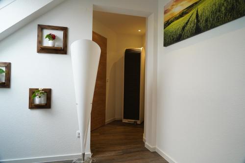 um corredor com um candeeiro de piso branco numa casa em Ferienwohnung Thulbatal em Oberthulba
