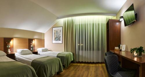 Oborniki ŚląskieにあるRestauracja Perłaのベッド2台とテレビが備わるホテルルームです。