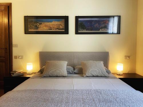 een slaapkamer met een bed met twee foto's aan de muur bij Rubbiano River Cottage in Solignano