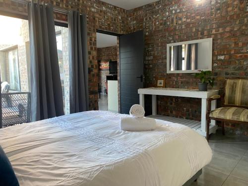 ein Schlafzimmer mit einem Bett und einer Ziegelwand in der Unterkunft SeaBreeze Guest Suite in Kapstadt
