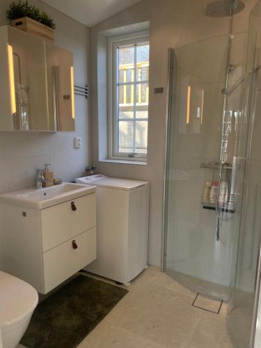 y baño con ducha, 2 lavabos y aseo. en Nybyggt hus med brygga, en Gränna