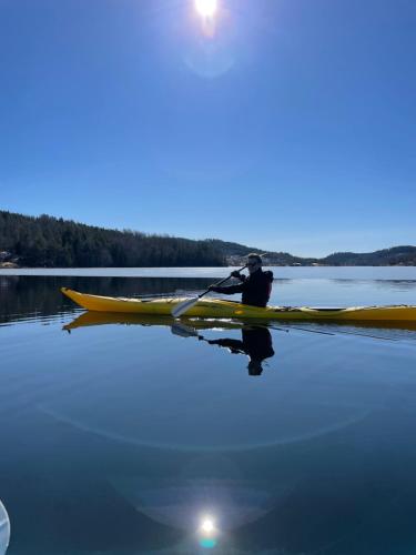 a man is paddling a kayak on a lake at New house by the lake Bunn & private bathing jetty in Gränna