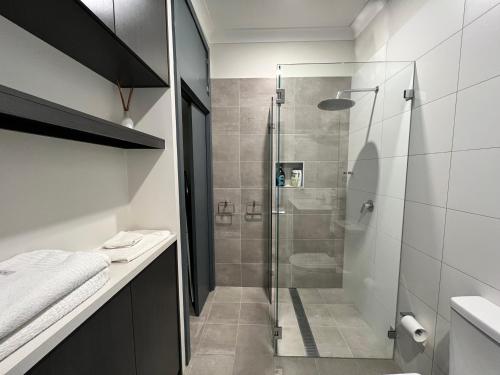 a bathroom with a shower with a glass door at Cosy Merewether Studio - sleeps one in Merewether