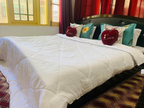 a white bed with two pillows on top of it at The Gurez inn hotel and restaurant in Kanzalwan