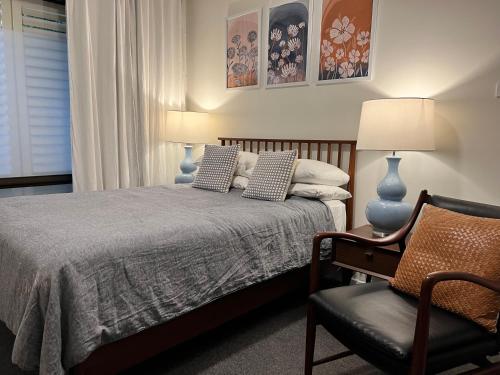 - une chambre avec un lit et une chaise dans l'établissement Cosy Merewether Studio - sleeps one, à Merewether