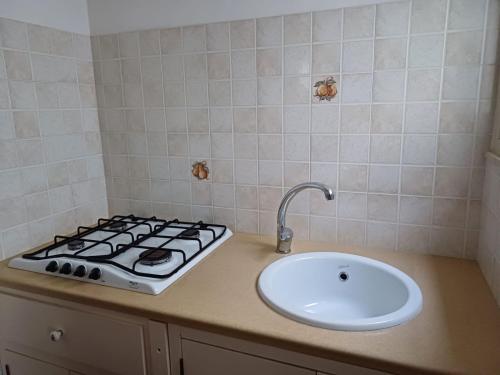 a kitchen counter with a stove and a sink at Casa Rosellina in Cefalù