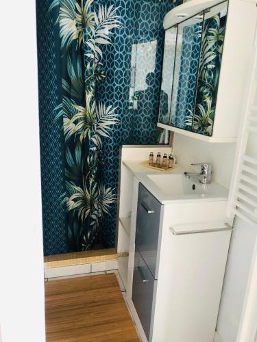 une salle de bain avec un lavabo et un miroir dans l'établissement Gîte au bord du lac, à Vernet-la-Varenne