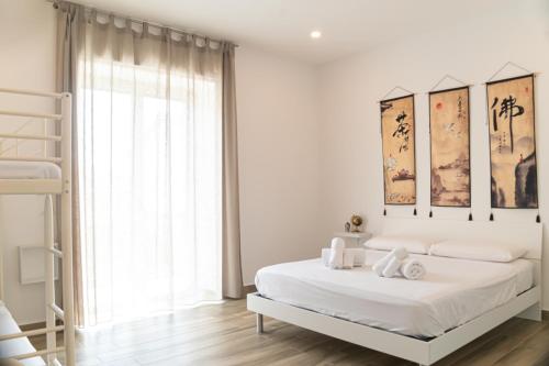 a white bedroom with a bed and a window at Il Giramondo in Agropoli
