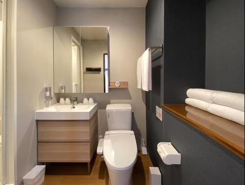 ein Badezimmer mit einem weißen WC und einem Waschbecken in der Unterkunft My Home Inn Izumisano in Izumi-Sano