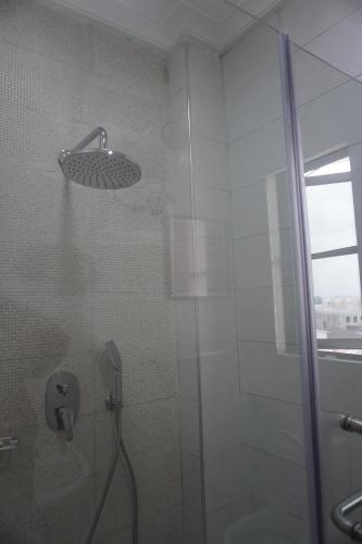 een badkamer met een douche en een glazen deur bij TodaStays Luxury Apartments in Lekki Phase 1