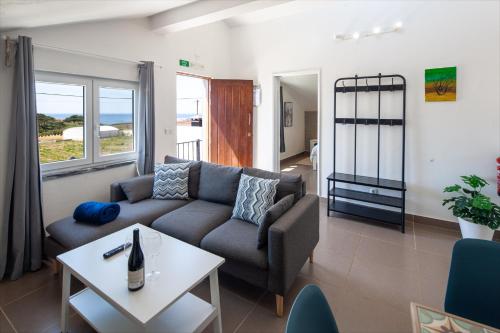 uma sala de estar com um sofá e uma mesa em Silvercoast Apartments - swimming pool & jacuzzi em Atouguia da Baleia