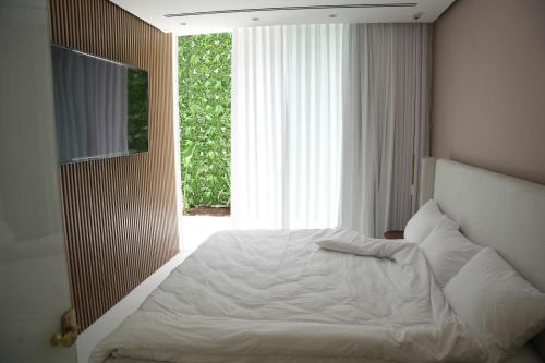 a bedroom with a white bed with a large window at אגם החלומות in Neve Zohar