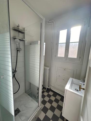 une salle de bain blanche avec une douche et un lavabo dans l'établissement Appartement 2 pièces lumineux, à Saint-Mandé
