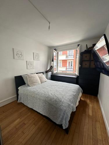 une chambre avec un lit et une fenêtre dans l'établissement Appartement 2 pièces lumineux, à Saint-Mandé