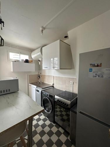 une petite cuisine avec un lave-linge et un sèche-linge. dans l'établissement Appartement 2 pièces lumineux, à Saint-Mandé
