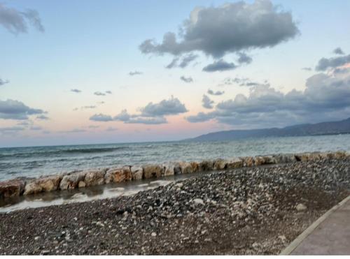 a beach with the ocean and a cloudy sky at Mountain View Apartment - Polis in Polis Chrysochous