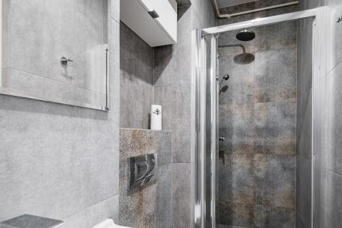 a bathroom with a shower with a glass door at Schindler's Studio WAWELOFTS in Krakow